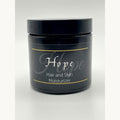 Black jar of 'Hope' hair and skin moisturizer on a white background